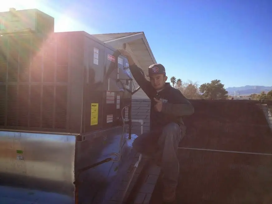 HVAC technician performing AC Tune-Up on a rooftop unit in Middleborough